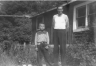 Duane Braham and Erwin Braham outdoors by cabin
